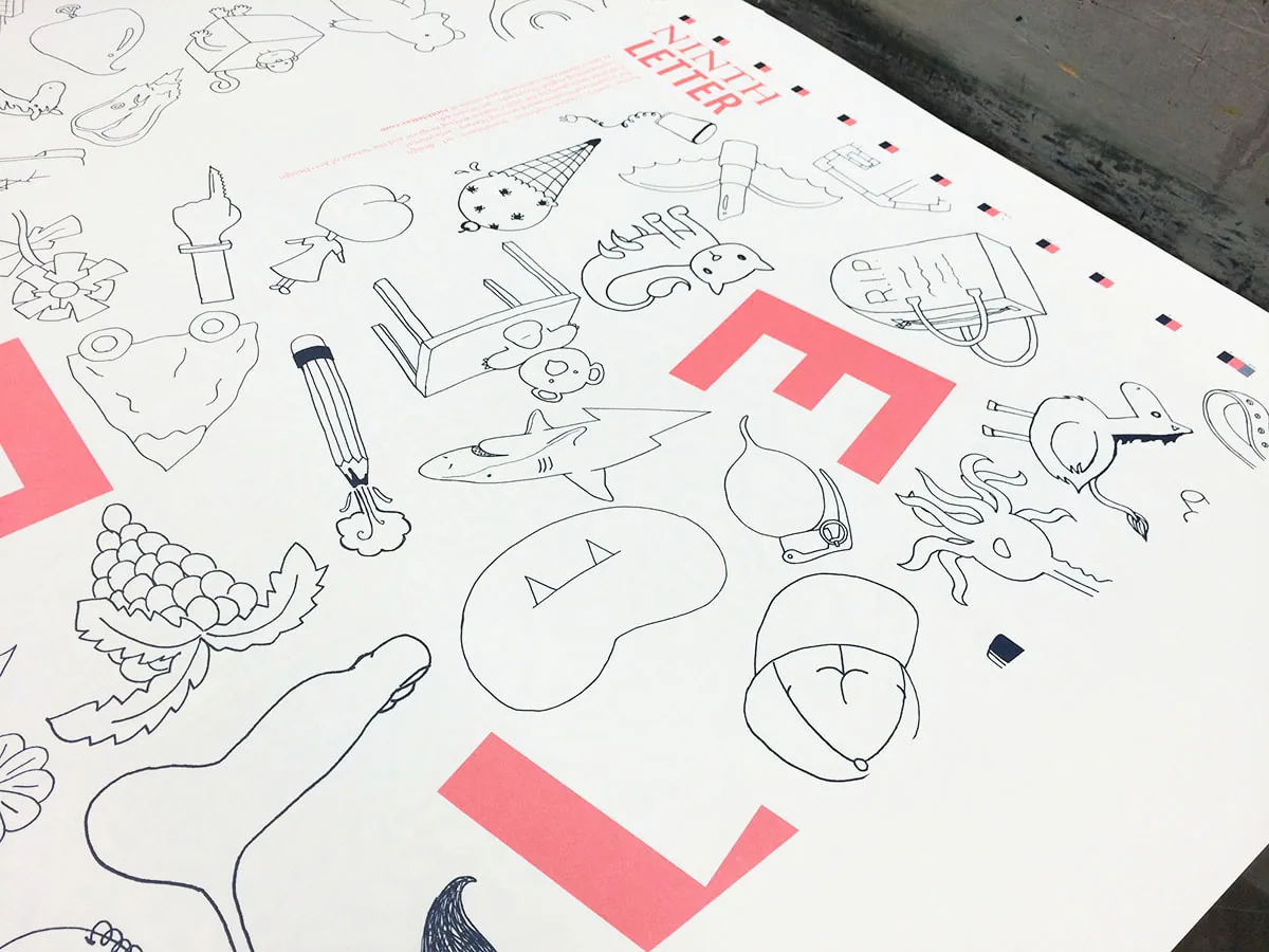 Close-up press check of the line-drawn object icons and a pink block letter mid-print