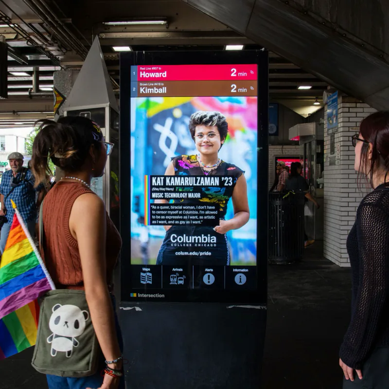 Digital ad on an “L” station kiosk featuring a Columbia student and her quote about not having to censor herself at Columbia, as two people look on