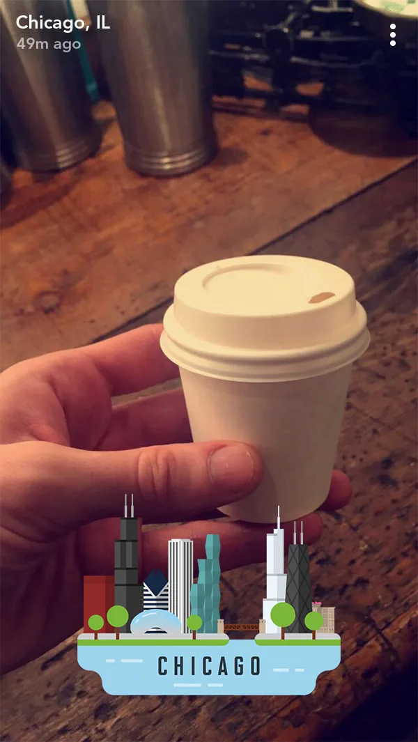 Chicago skyline geofilter appearing on a Snapchat photo of a coffee cup held in hand