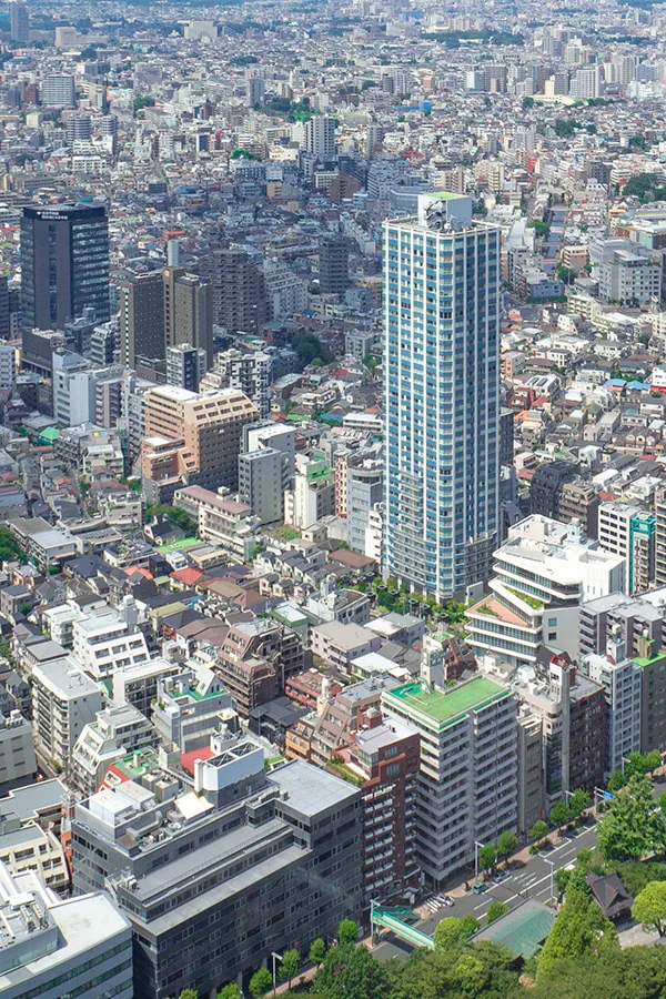 Bird's-eye view of a slender high-rise tower rising sharply above a sea of smaller rooftops