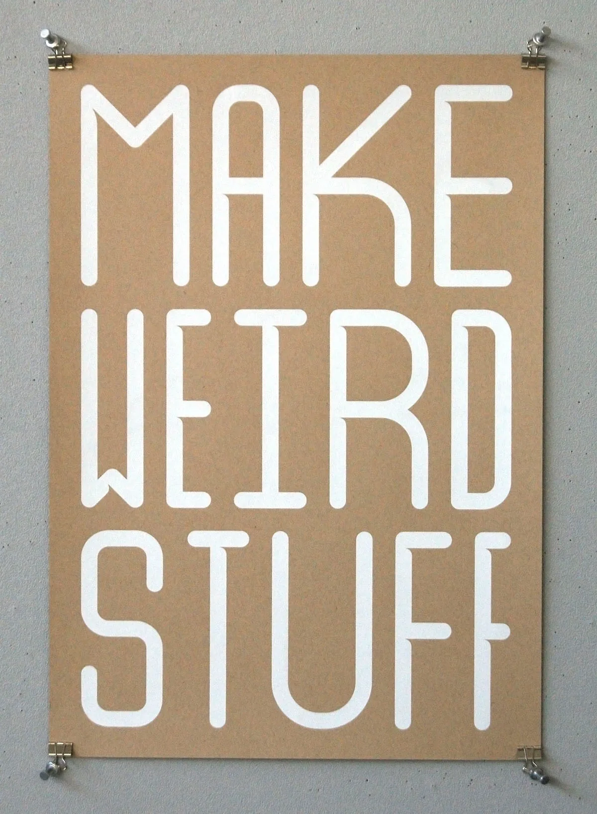Screen print reading ‘MAKE WEIRD STUFF’ in bold white sans-serif letters on kraft-colored paper